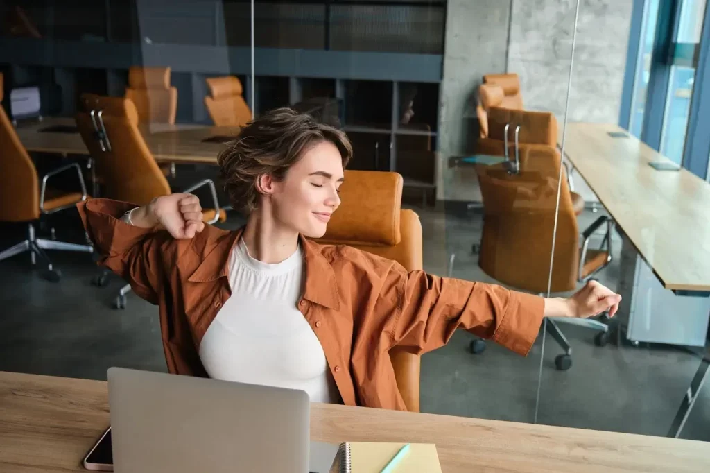 Mujer se estira cómodamente en un breve descanso en su coworking.