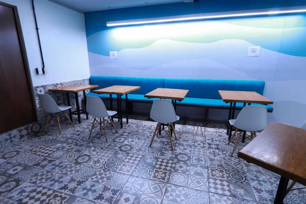 Comedor en Works+, Querétaro, con sillas y sillones en unión con las mesas.