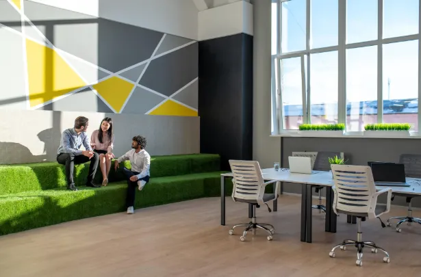 Tres trabajadores conversando en un coworking